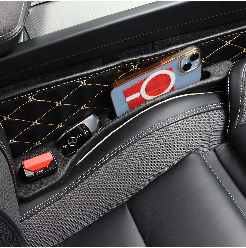 Comblement d’interstice de siège élégant en cuir noir, avec surpiqûres dorées et surface texturée, conçu pour maintenir solidement un smartphone dans un siège de la classe AMG GLC.