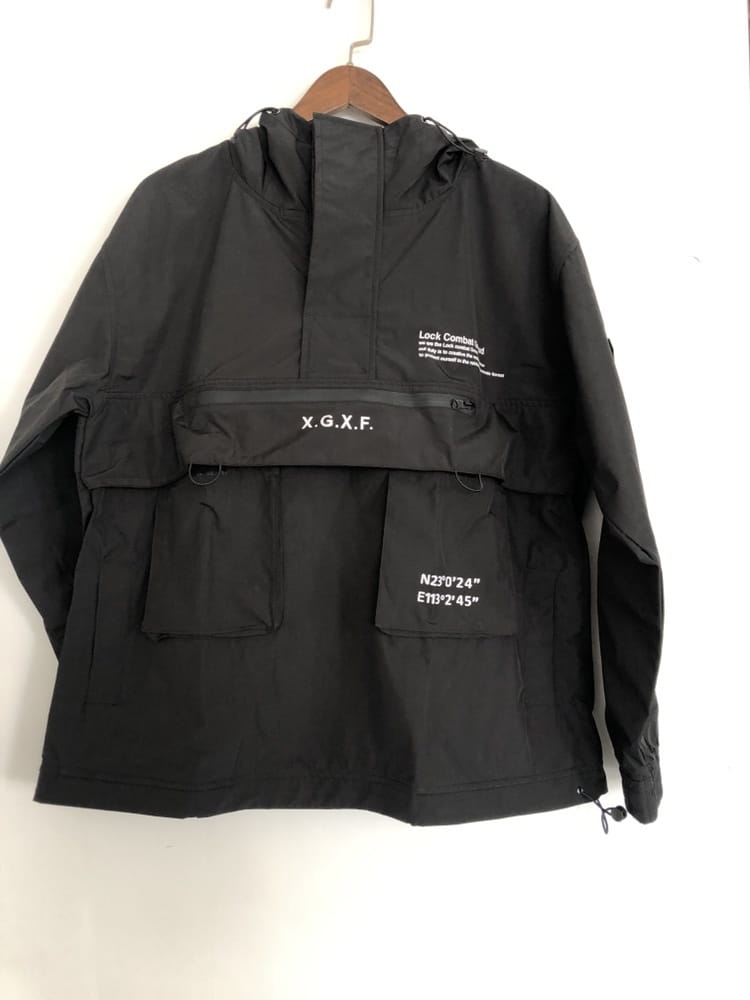 Veste imperméable à capuche tactique techwear noire x.g.x.f, présentée de dos, avec une matière durable et résistante à l’eau conçue pour un usage en extérieur.