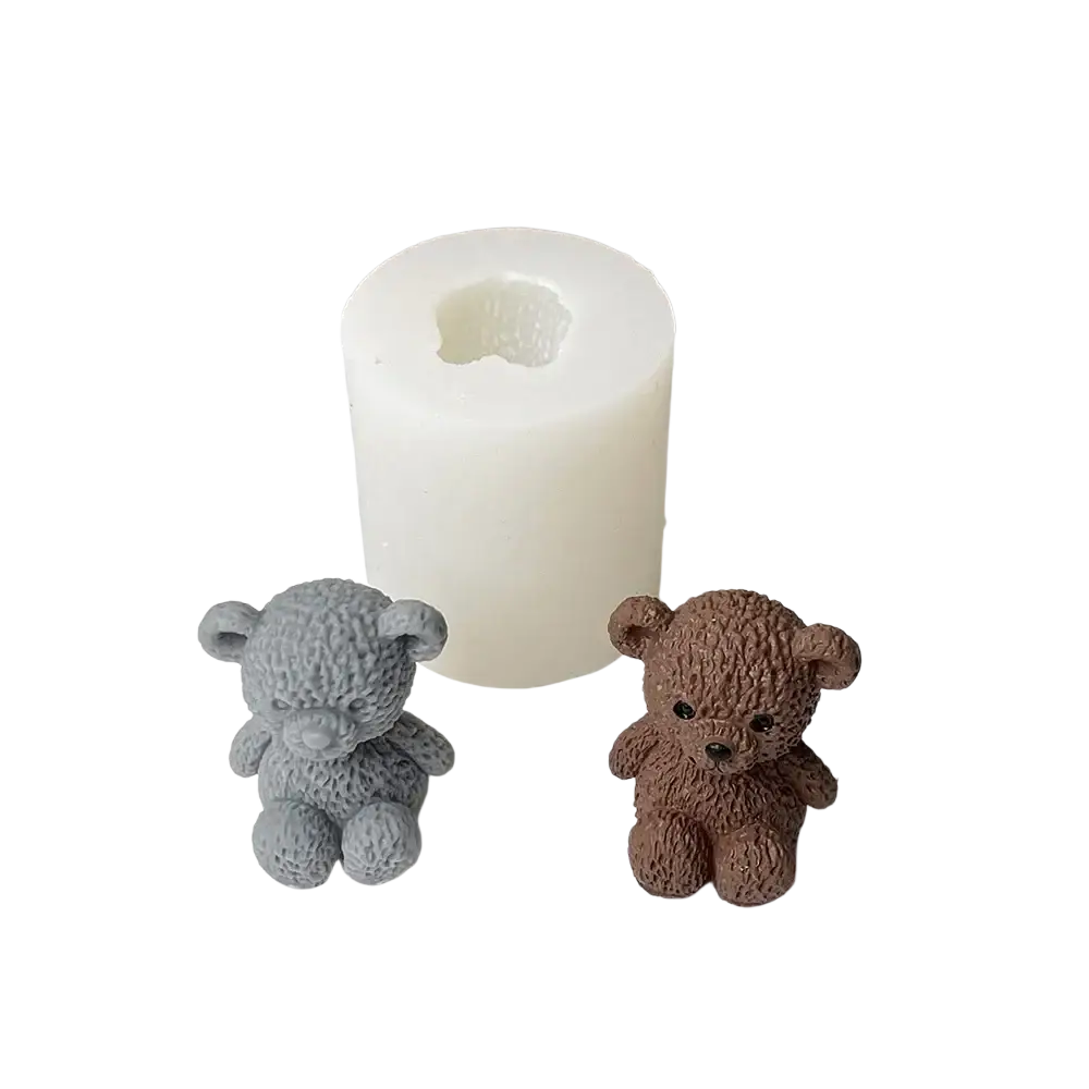 Front view of gray and brown textured mini teddy bear candle figurines beside a white cylindrical silicone mold for candle making