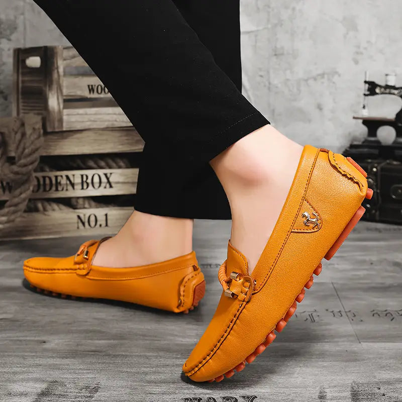 Chaussures à enfiler habillées en cuir orange pour hommes, avec des accents de boucle métallique et une semelle texturée, conçue pour un port décontracté sans effort.