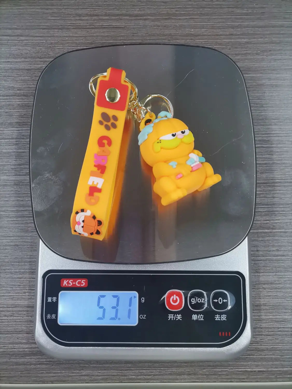 Yellow rubber keychain featuring a cartoon Garfield cat figure with red accents designed as an anime cat key pendant.
