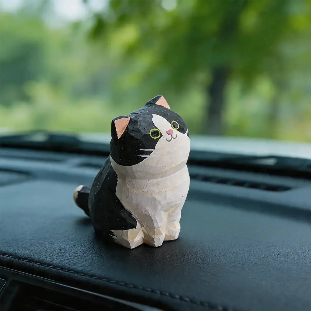Handcrafted wooden cat figurine desk decor featuring a charming black and white carved design with pink inner ears, green eyes, and a tiny nose, available as an actual product factory direct.