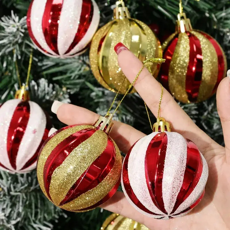 Hand holding a red and gold glitter-striped christmas ball ornament with a shiny metallic finish from a set of 6 christmas tree ornaments measuring 6cm each.