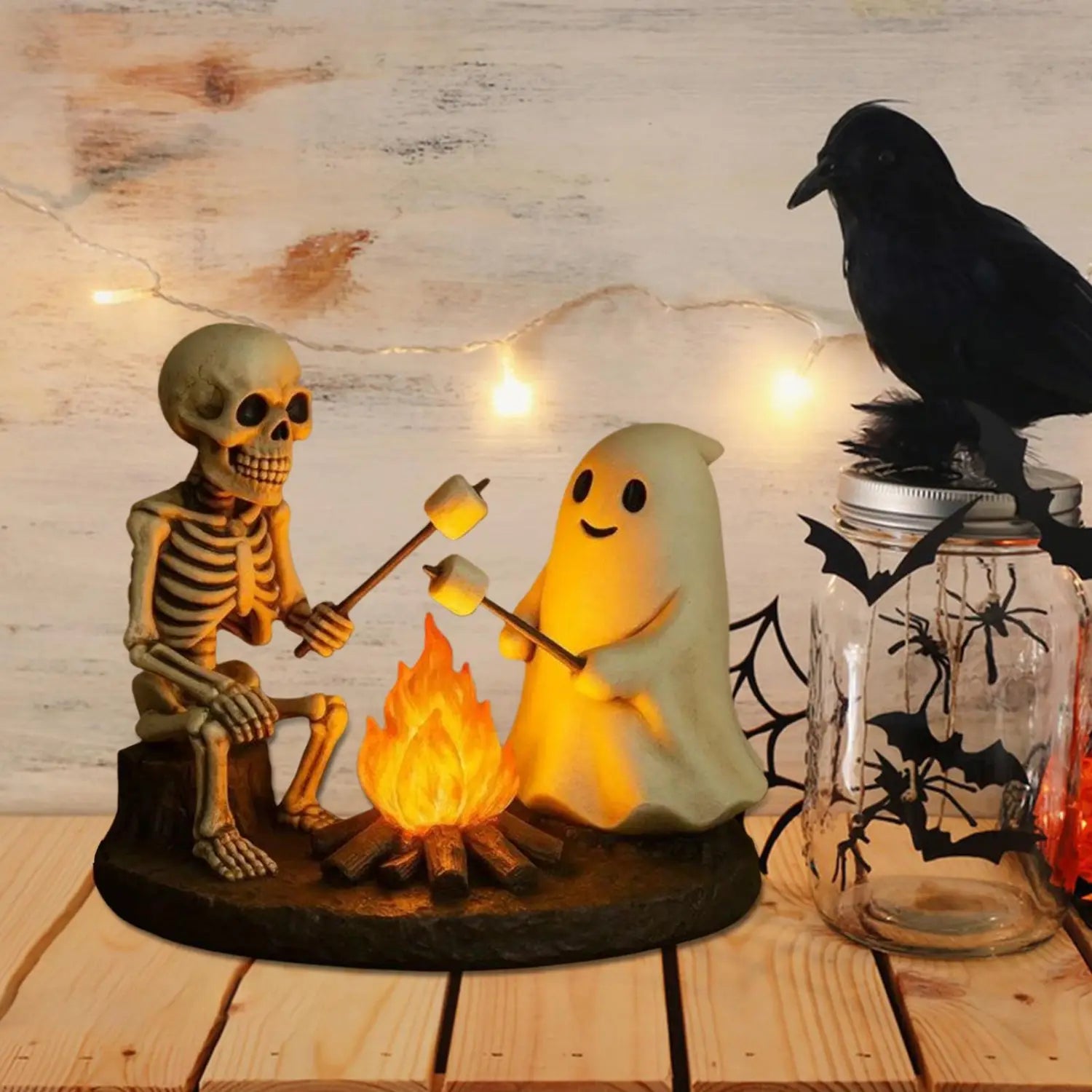 une lanterne de nuit de feu de camp fantomatique lumineuse thématique Halloween, avec un fantôme squelette et une figurine de fantôme rôtissant des guimauves près d’un feu de camp illuminé, pour la décoration d’Halloween