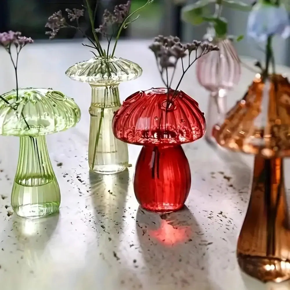 a vibrant red glass mushroom bud vase with a ribbed cap and stem holding delicate dried flowers serving as a colorful nordic plant holder