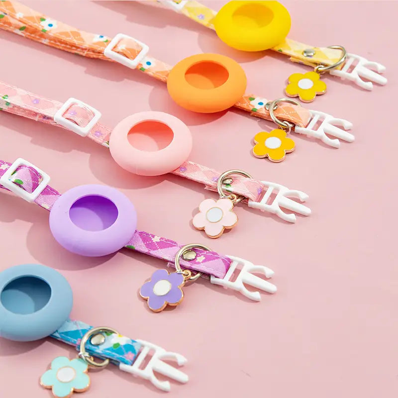 Pastel-colored silicone airtag protective case phone ring with floral-patterned strap and matching flower charm designed for outdoor park dog and park dog cat use.