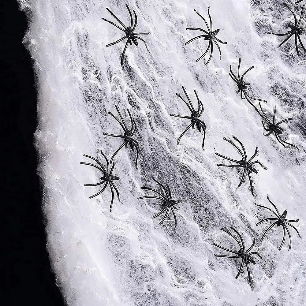 black plastic spiders scattered across a white textured spiderweb as part of horror props halloween hanging skull ghost decoration for props halloween party use