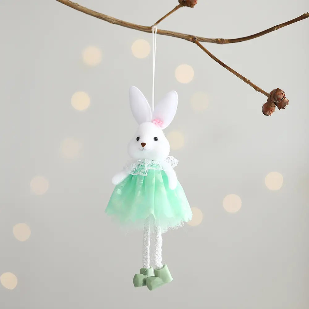 Ein weißer Plüschhasen-Anhänger aus dem Oster-Feen- und Osterhasen-Anhängeset, gekleidet in einen mintgrünen Tüllrock mit Spitzensaum und passenden Stiefeln, der von einem Zweig hängt.