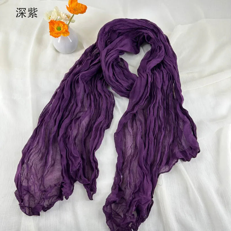 Écharpe en coton et lin plissé violet profond, avec une texture de mousseline de chiffon froissée et un tombé fluide et souple.