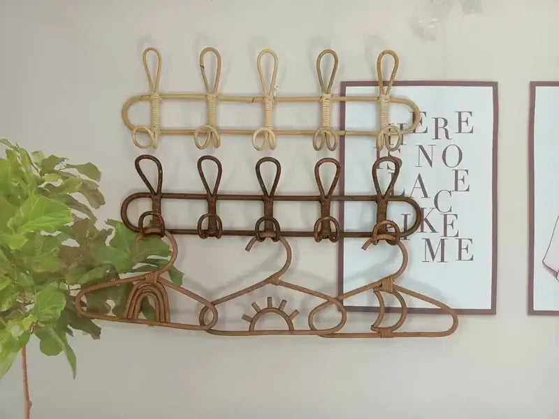 Rattan-Kinder-Wandhaken zur Aufbewahrung von Kleidung mit zwei Hakenreihen in naturbeigen und dunkelbraunen Farben, an der Wand montiert.