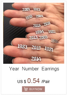 silver year number earrings engraved with different birth years paired with a gold angel number 7 necklace