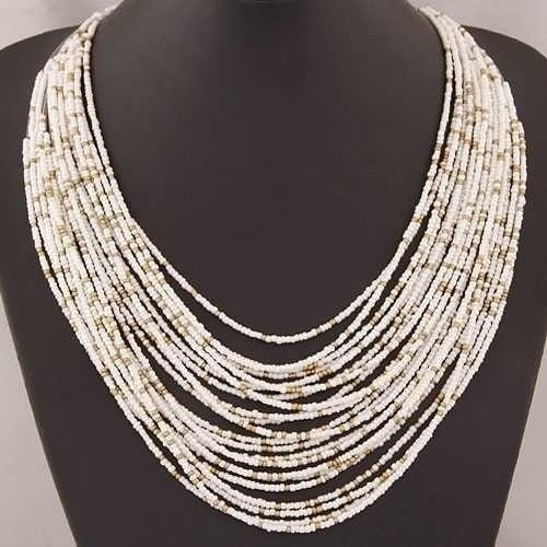 Boho multi-layer bead statement necklace featuring multiple strands of small cylindrical white beads with subtle natural variations in tone and texture.