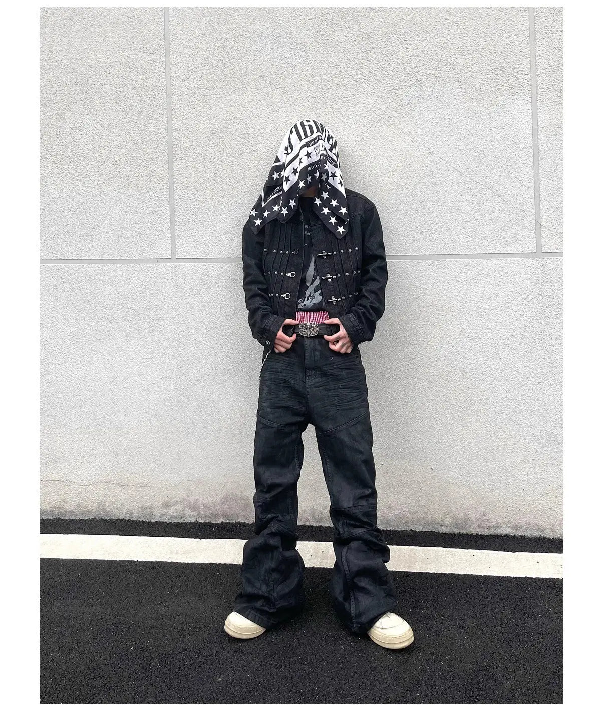 Jeans empilés en denim noir Y2k vintage pour hommes associés à une veste en denim noire présentant des clous argentés et une écharpe à motif d’étoiles drapée sur la tête