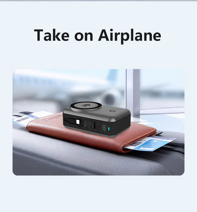 Black compact portable power bank with solid-state battery featuring multiple USB ports and a magnetic wireless charging pad on top resting on a brown leather wallet.