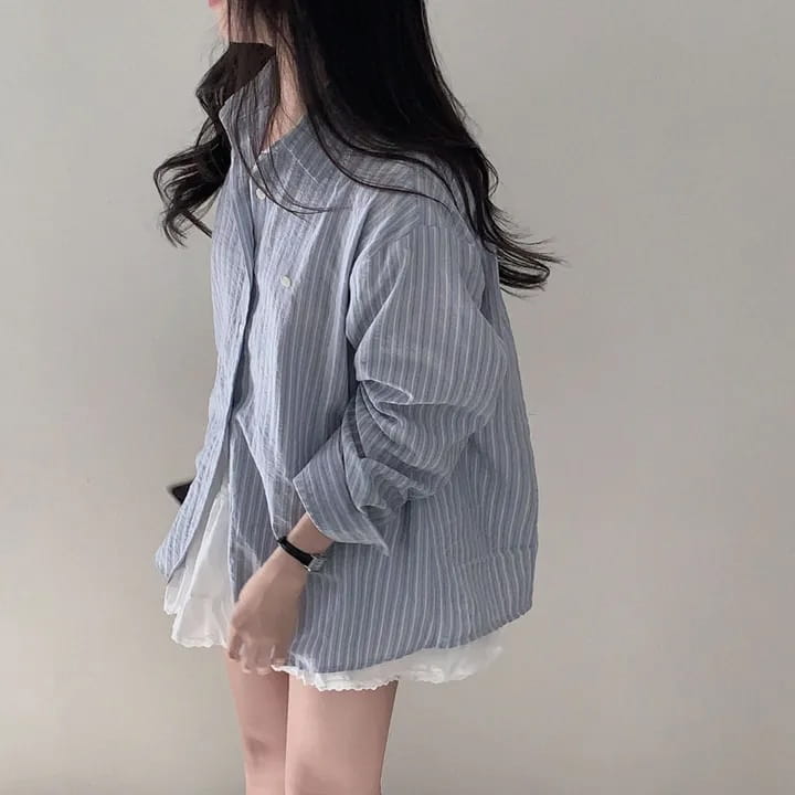 striped long sleeve button down shirt featuring a versatile style with a light blue and white vertically striped pattern made of textured cotton in standard thickness for comfortable wear.