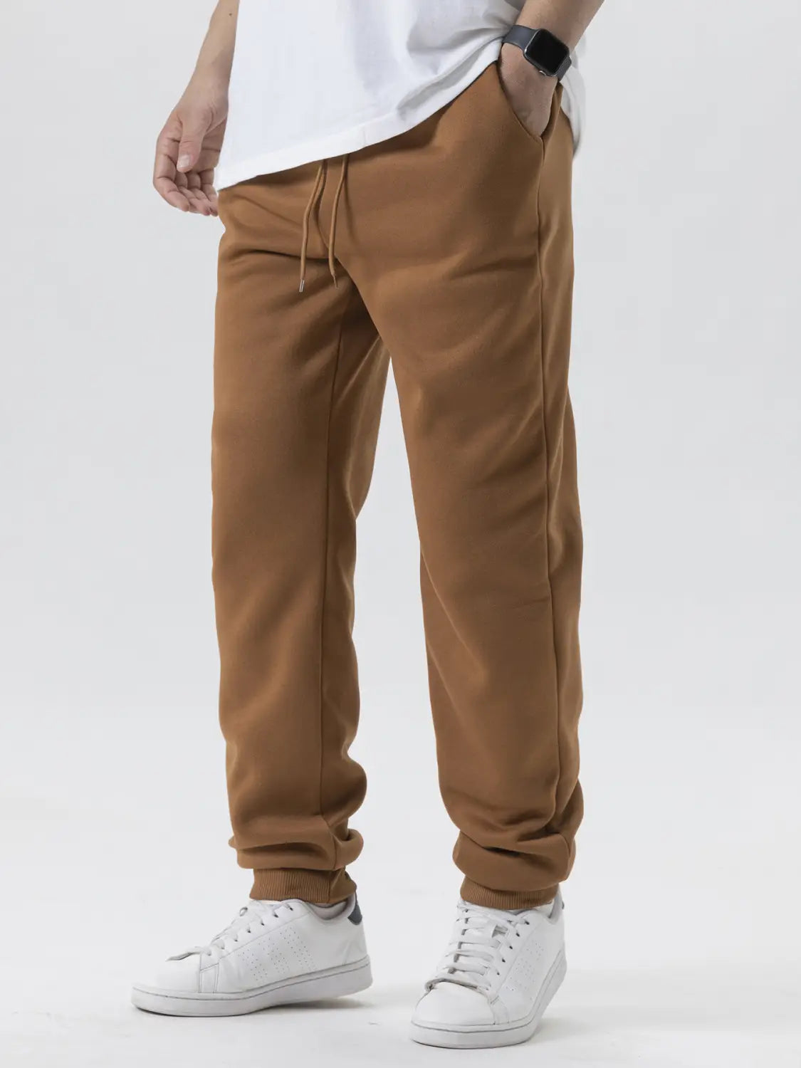 Joggers en polaire camel raccourcis, avec une taille à cordon de serrage et des poignets élastiques, conçus pour une tenue d’hiver décontractée.
