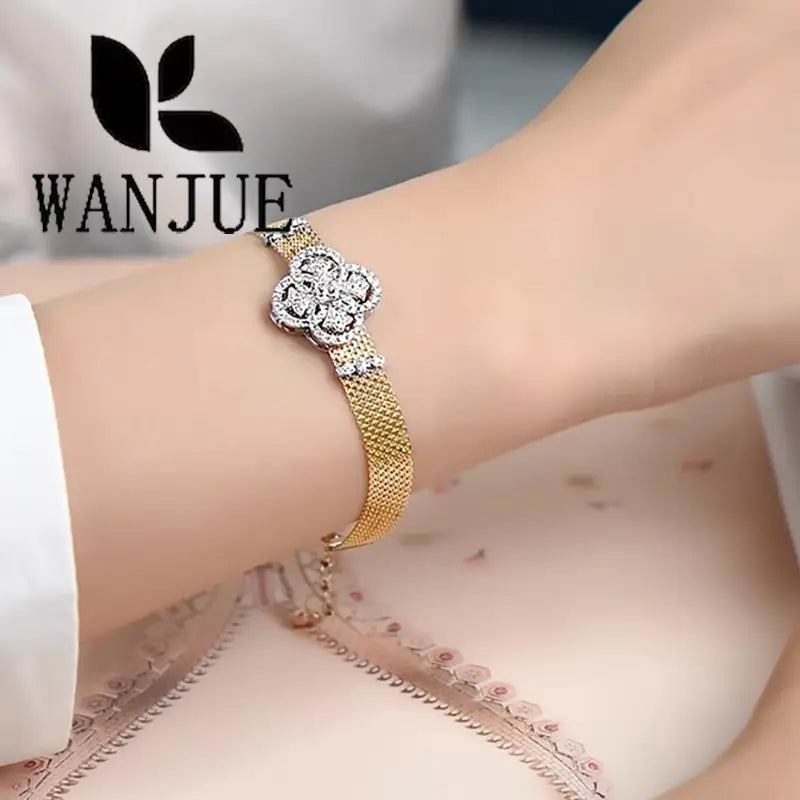 Wanjue brand crystal flower gold mesh cuff bracelet featuring a sparkling diamond-encrusted clover-shaped clasp.