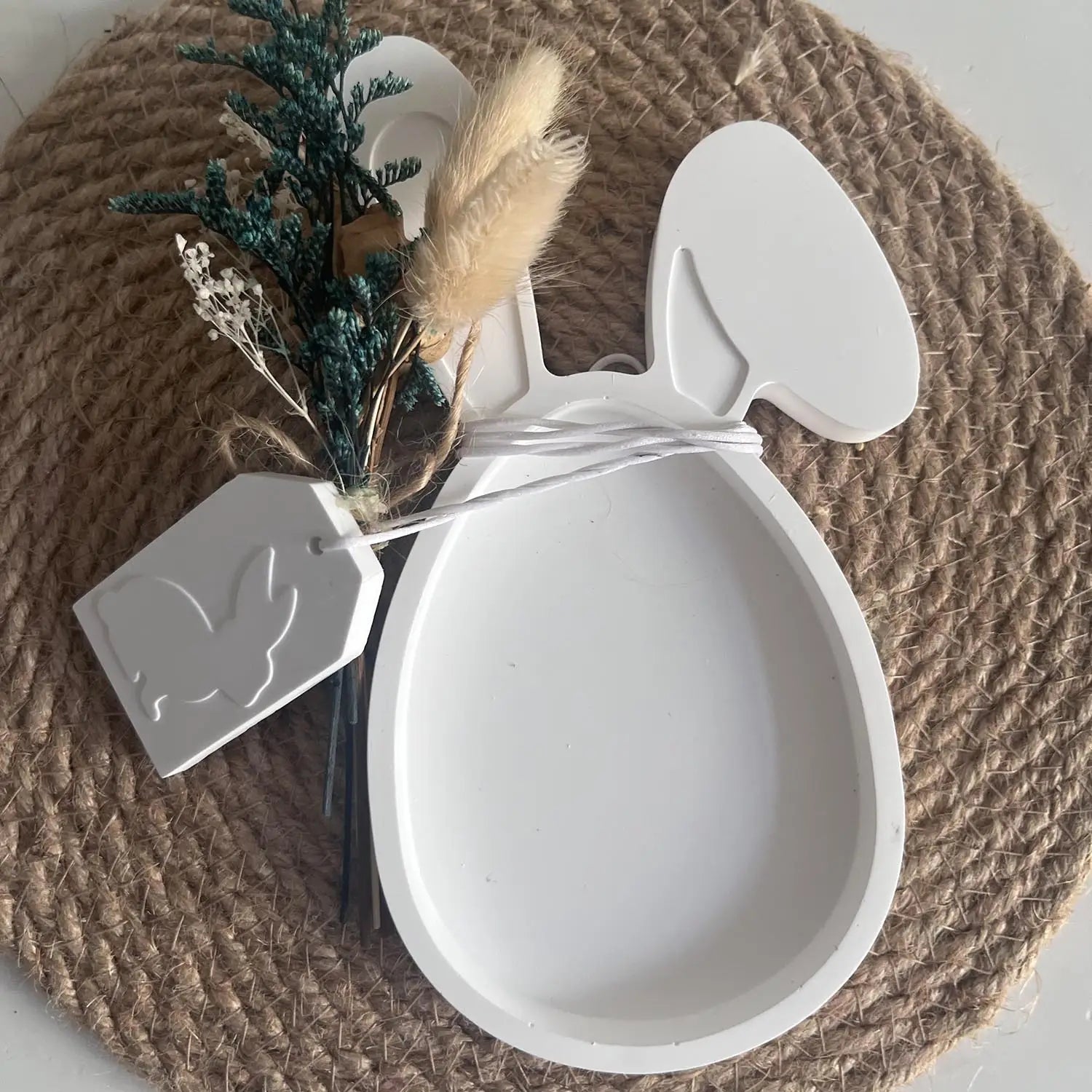 White bunny-shaped ceramic dish with a smooth matte finish and two upright ears used as an Easter bunny silicone resin pendant mold.