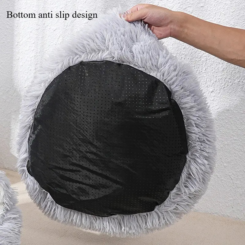 Cama redonda para gato de felpa color gris, con suave piel sintética gris y una base negra perforada antideslizante para el anidado de la mascota y el mantenimiento del calor.