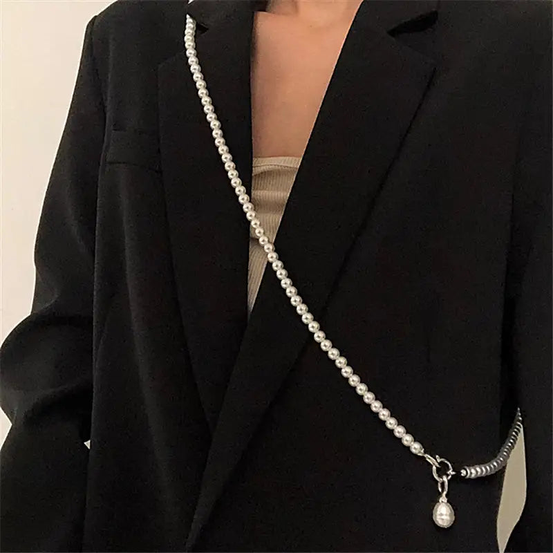 Un long collier délicat en perles à l’aspect argenté, en pendentif pour femmes, présentant un seul petit breloque en forme de goutte pendante.
