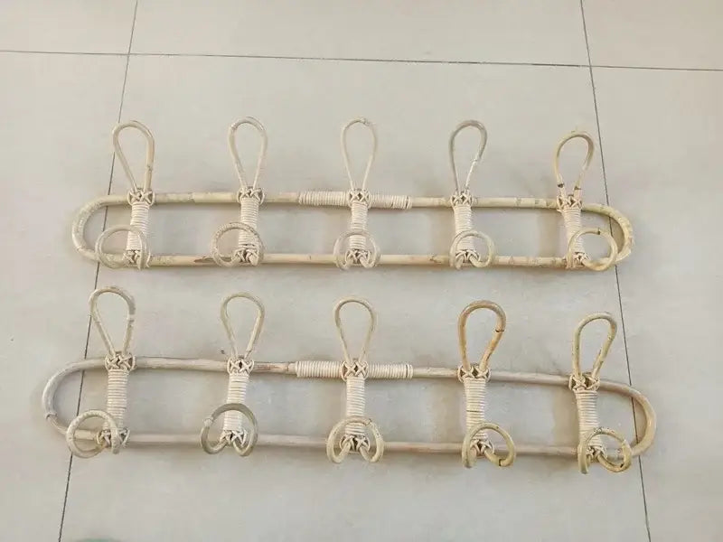 Zwei beiger Rattan-Kinder-Wandhaken zur Aufbewahrung von Kleidung mit jeweils fünf Haken, nebeneinander angeordnet zur Organisation von Kinder-Oberbekleidung.