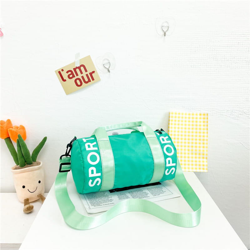 Mintgrüne zylindrische Kinder-Sport-Reise-Sporttasche mit reflektierender weißer Sportbeschriftung und passendem verstellbarem Riemen, entworfen für Reise-, Gym- und Crossbody-Gepäck.