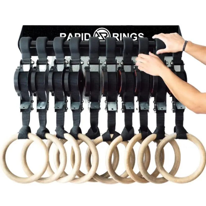 Set of eight black and natural wood wooden gymnastics rings with numbered adjustable straps branded rapid rings.
