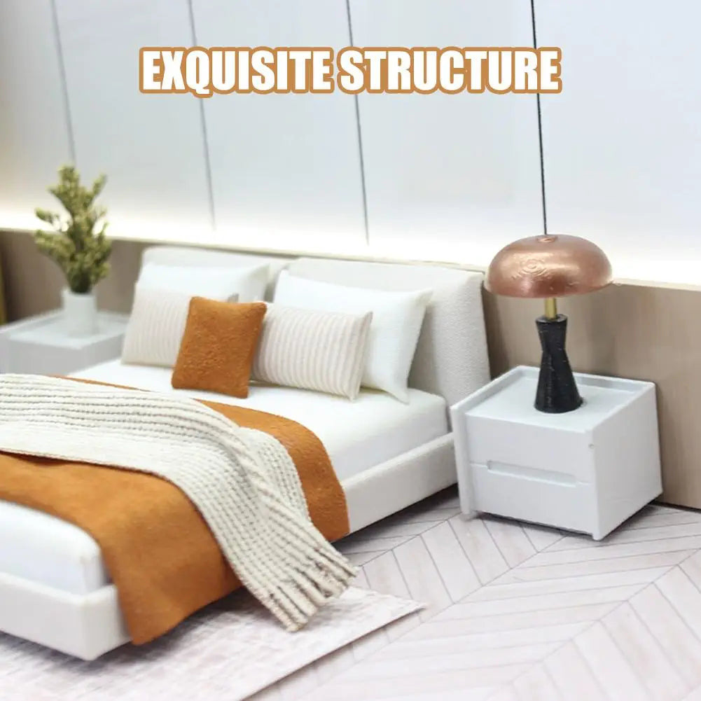 miniature dollhouse double bed with cream bedding style displayed next to a copper-finished mushroom-shaped table lamp with a black base on a white nightstand