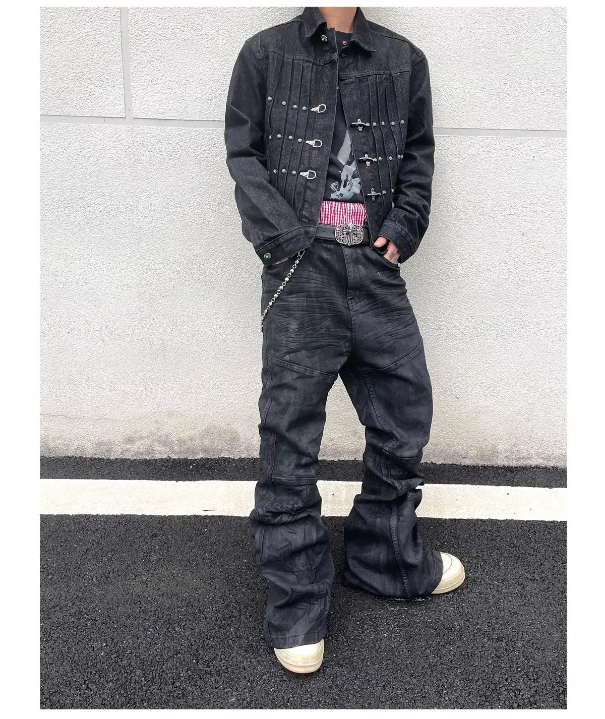 Jeans empilés en denim noir Y2k vintage pour hommes associés à une veste en denim noire présentant des accents de quincaillerie argentés et une texture légèrement usée.