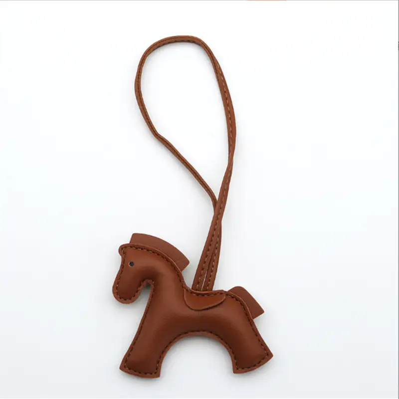Porte-clés en cuir marron en forme de cheval avec détails cousus et boucle assortie pour la fixation.
