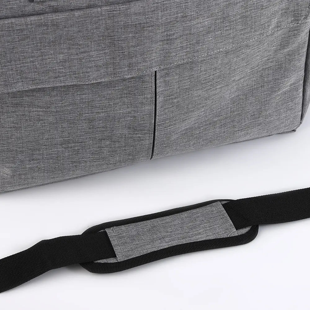 Sac de voyage pour chien en tissu gris à texture, avec fermeture éclair, comprenant une sangle d’épaule réglable noire, conçu pour un transport pratique de l’animal.