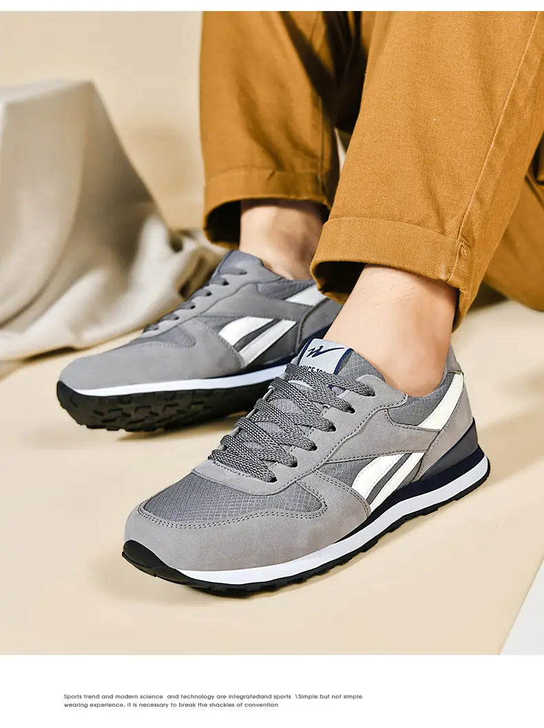 Herrenfreizeitsneaker in Grau und Weiß zum Gehen mit Mesh-Obermaterial, Wildleder-Akzenten und schwarzen Gummisohlen.