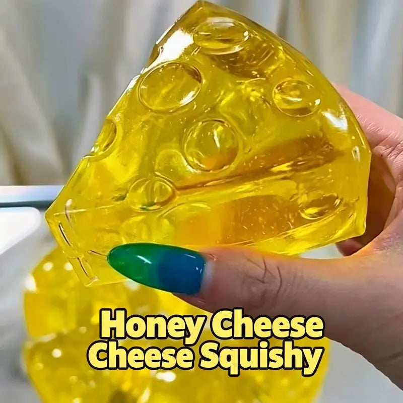a translucent yellow honey-colored triangle cheese fidget toy with embedded circular holes and a glossy finish designed as a soft stress relief squeeze toy