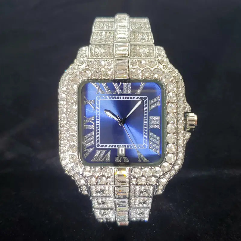 A dazzling iced out diamond square watch for men in silver with a deep blue dial roman numerals and an intricate sparkling diamond encrusted band.