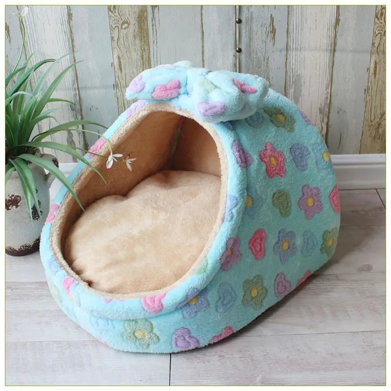 Light blue plush foldable pet cave bed with colorful floral patterns and soft tan interior lining for small dogs and cats.