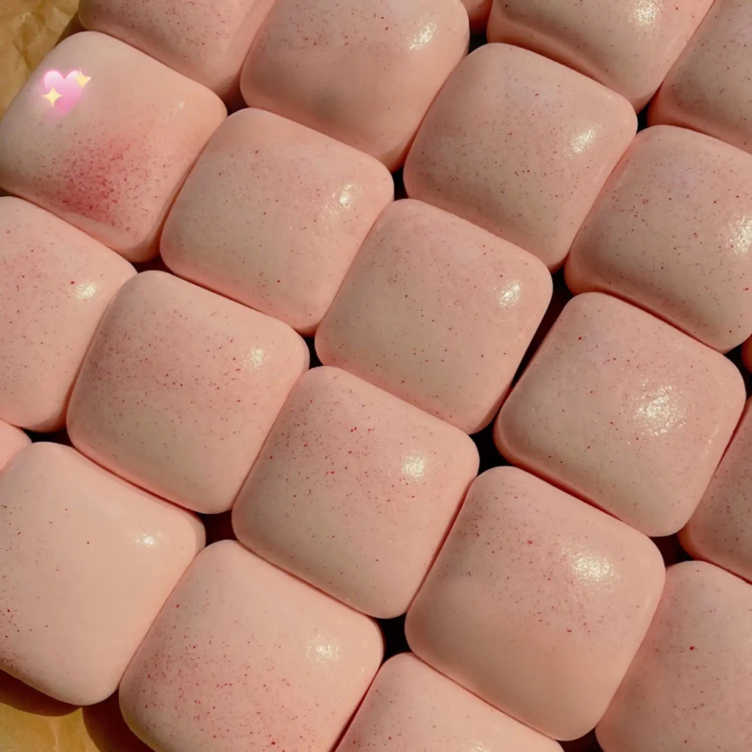 mini toast à dégagement lent, jouet sensoriel d’agitation, montrant des morceaux de chewing-gum carrés roses, présentant une texture mouchetée, vus de face.