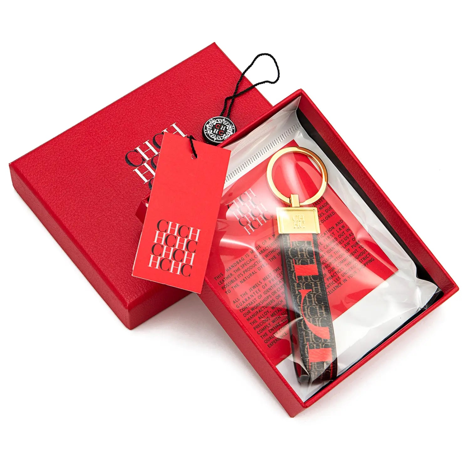 Red and black patterned leather logo keychain with gold-tone metal ring and branded plaque designed as a fashion accessory gift.