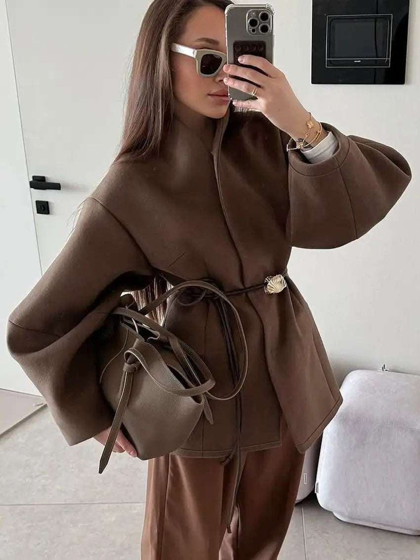 brown leather bucket bag with drawstring closure and gold-toned shell-shaped buckle featured with wool belted coat brown winter jacket