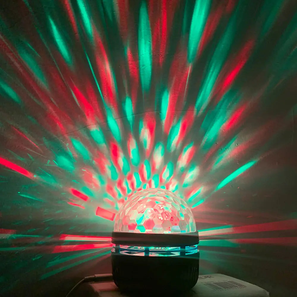 Un projecteur lumineux de ciel étoilé comprenant une coupole de boule disco facettée transparente, dotée d’une base noire, émettant des faisceaux laser rouges et verts vibrants, idéal pour des veilleuses.