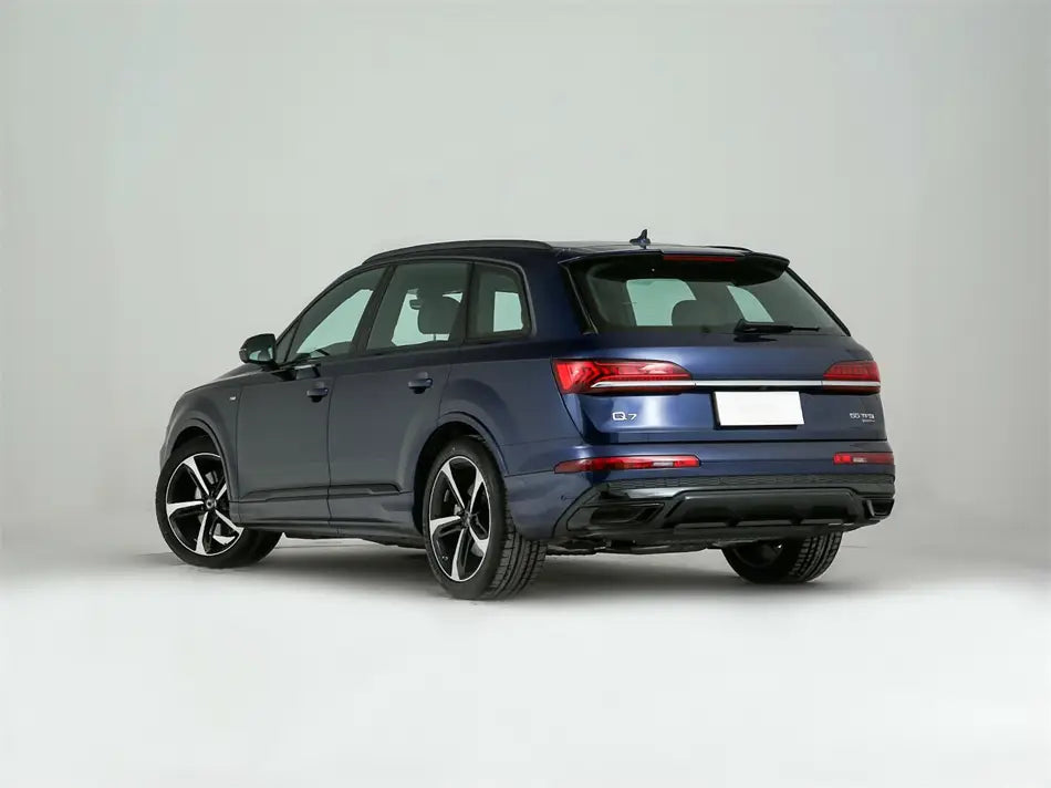 Véhicule utilitaire sport Audi Q7 2020-2024 en métal bleu foncé, avec jantes noires élégantes en alliage, présentant le design arrière sportif et le couvre-carter de remplacement du feu arrière.