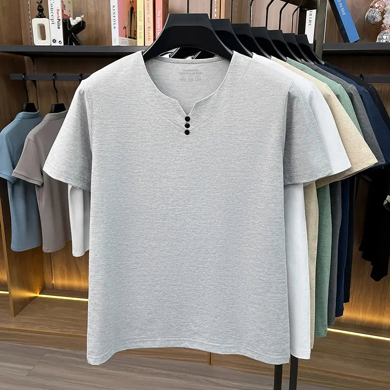 Camisa tipo henley para hombre de manga corta en algodón gris claro jaspeado con tres botones negros en el cuello, para una apariencia informal con textura.