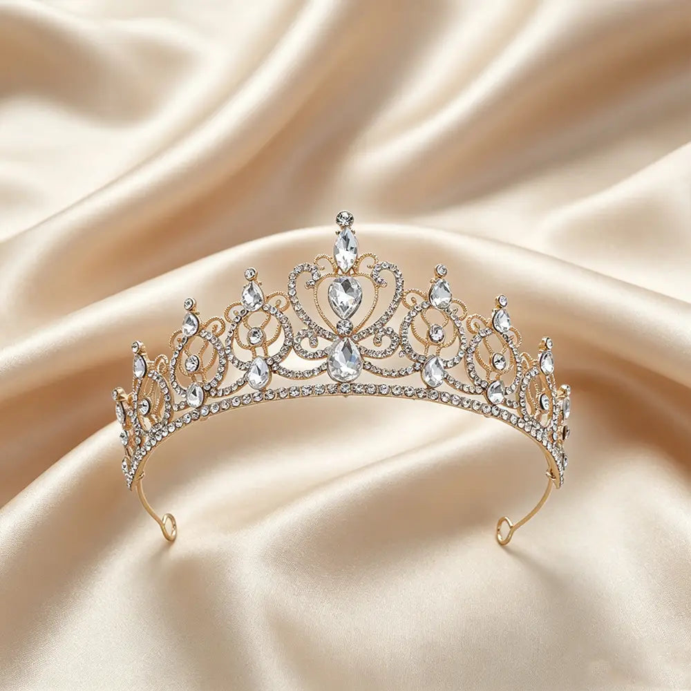 Une délicate couronne de diadème baroque en strass doré, ornée de cristaux transparents étincelants et de détails de filigrane complexes pour accessoire de coiffure de mariée.
