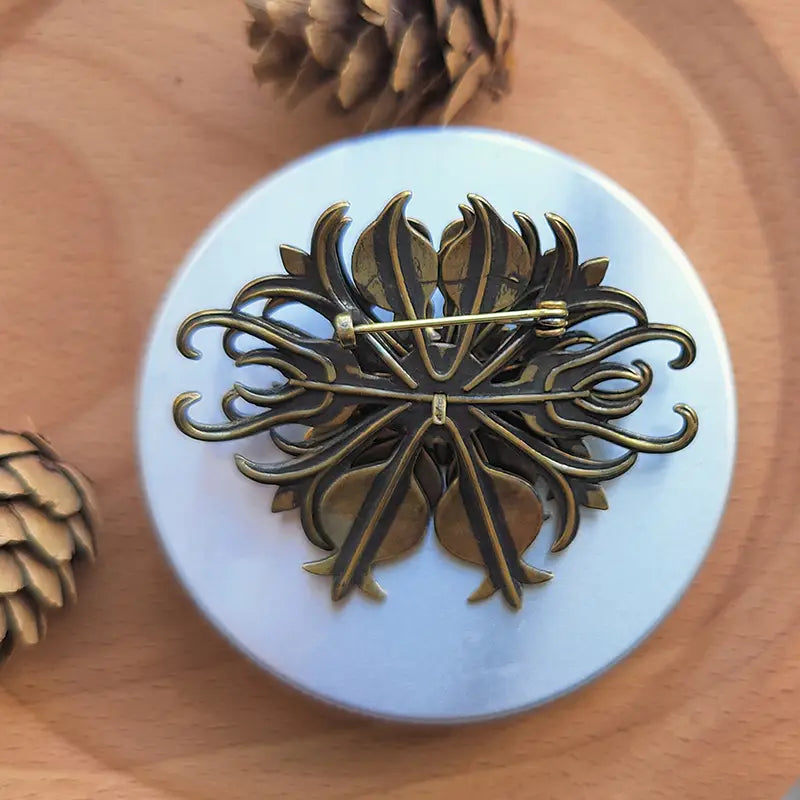 Antique brass filigree brooch with intricate turquoise floral leaf and petal design for palace jewelry.