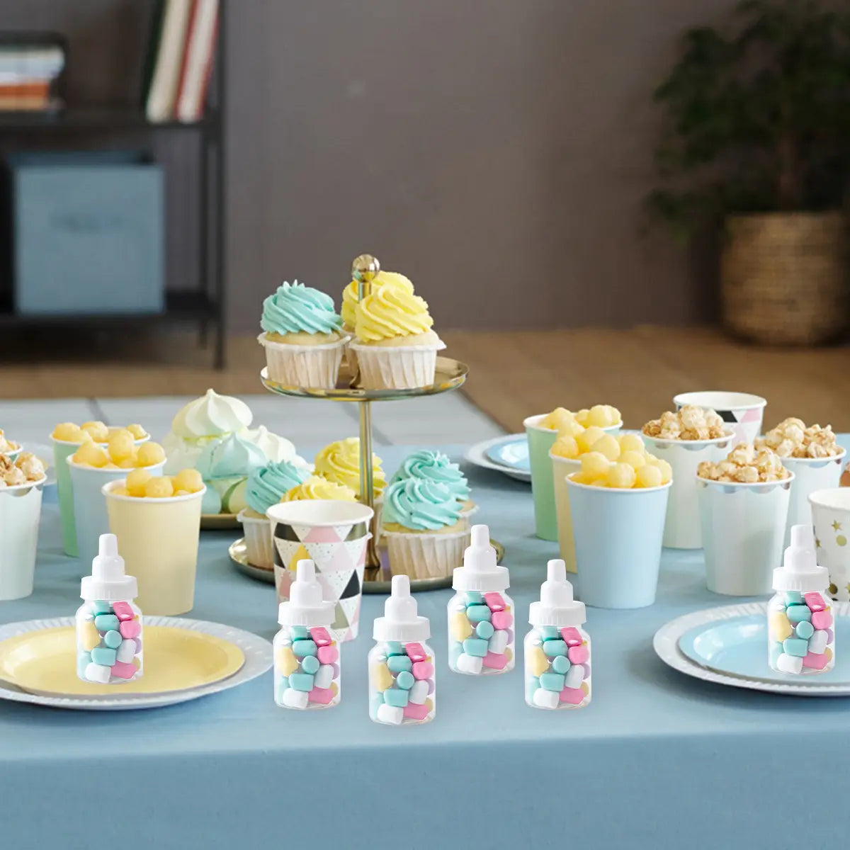tarros de caramelo con forma de biberón para bebé, de colores pastel, con cuerpos de plástico transparente y tapas blancas diseñadas como recuerdos de fiesta con temática de revelación del género.