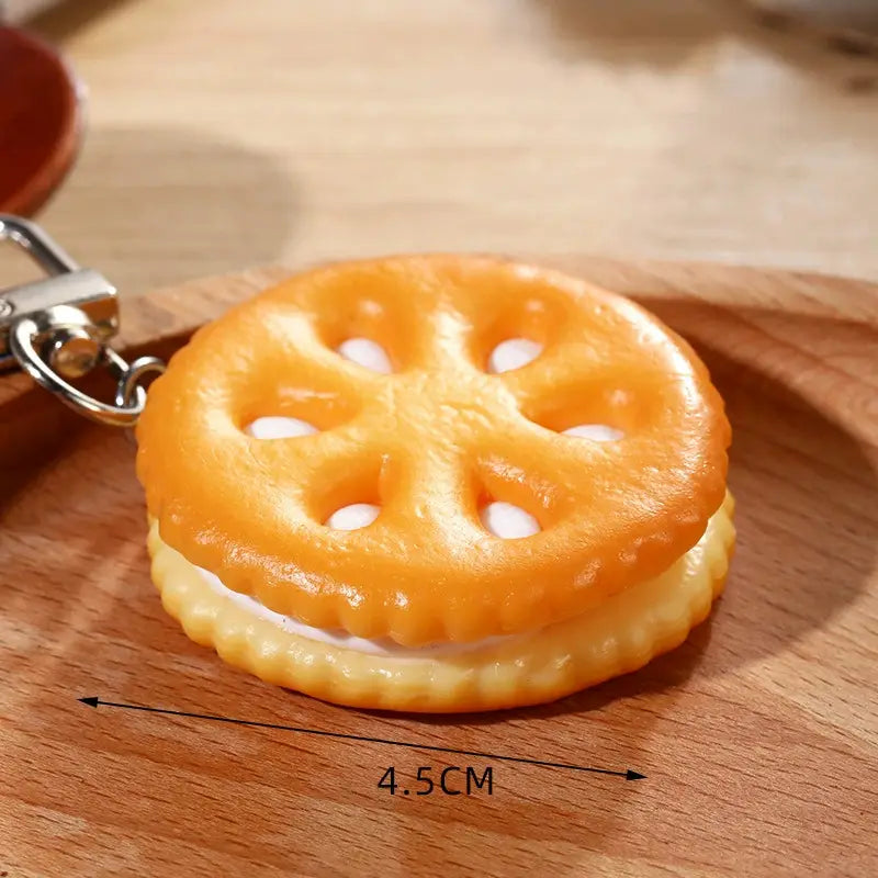 Orange and white sandwich cookie keychain with a realistic glossy plastic finish featured as a chocolate biscuit cartoon key chain bag pendant.