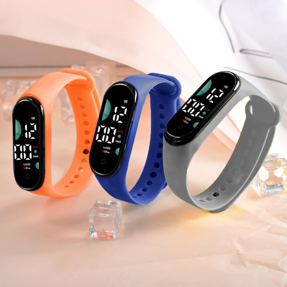 three electronic watches with large font screens and silicone bands in orange blue and gray designed for digital sports and waterproof use