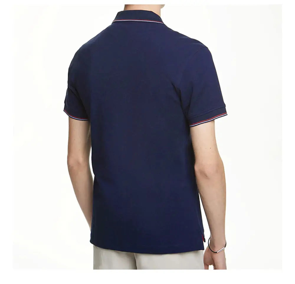 Herren-Poloshirt aus Baumwolle in Marineblau mit kurzen Ärmeln, mit rot-, weiß- und blauem Kontrastbesatz am Kragen und an den Ärmelbündchen.