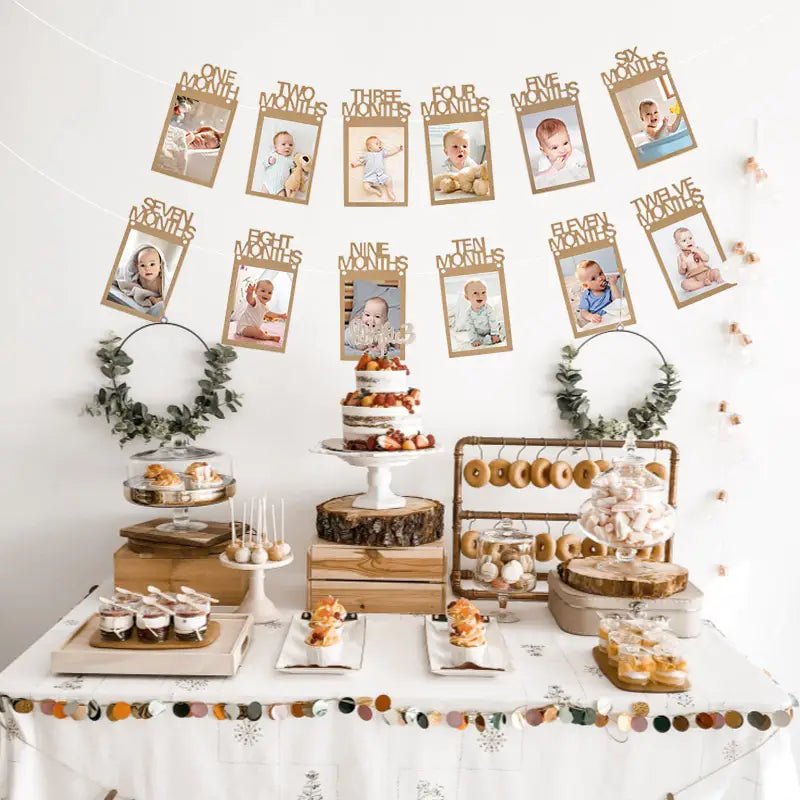a tiered white frosted cake topped with fresh fruit displayed on a rustic wooden stand for a 1st birthday photo banner monthly picture garland setup