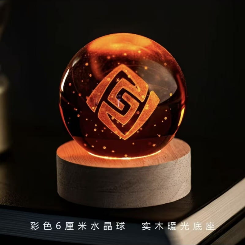 Une sphère de verre de couleur ambre lumineuse, portant un logo géométrique gravé, reposant sur une base en bois : il s’agit d’une boule de cristal produit fini de Genshin Impact.