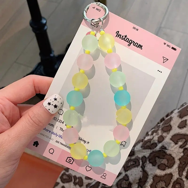 Pastellfarbene mit Jelly-Gelperlen gefertigte Handy-Handgelenksschlaufe mit silbernem Metallring zum einfachen Anbringen und mehrfarbigem Charm-Design.